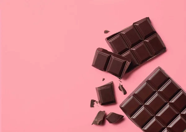 ピンクの背景のダーク チョコレート — ストック写真