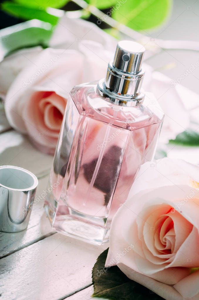 Perfume bottle and pink roses. 