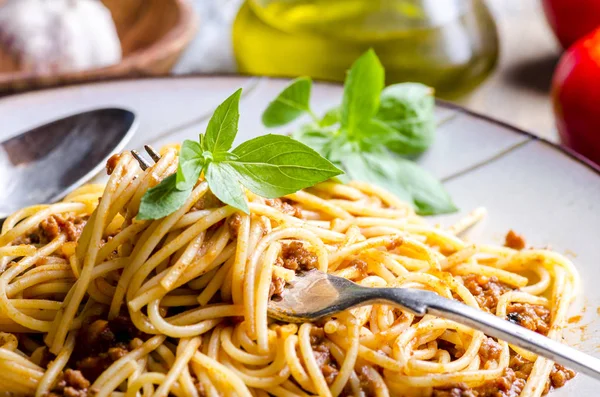 Primer plano de los espaguetis italianos boloñeses con albahaca en tenedor. Tradi —  Fotos de Stock