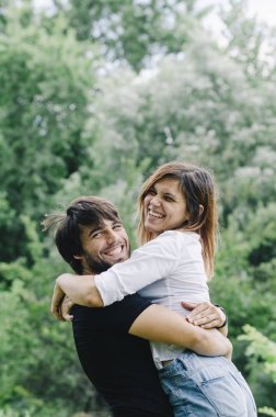 Happy couple kissing and hugging in nature. Young man and woman 