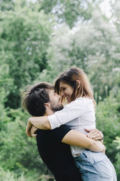 Pareja feliz besándose y abrazándose en la naturaleza. Joven hombre y mujer —  Fotos de Stock