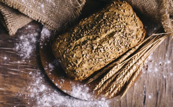 Widok z góry domowej roboty bochenek chleba z pełnoziarnistej pszenicy na vintage — Zdjęcie stockowe