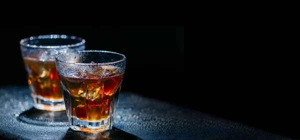 Dois copos de bebida alcoólica fria no fundo preto sagacidade — Fotografia de Stock