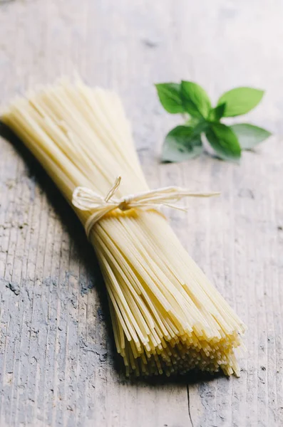 Italienische rohe Pasta auf rustikalem Holztisch. — Stockfoto