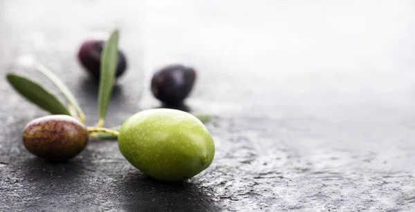 Primo piano di frutta fresca di oliva su sfondo scuro strutturato con co — Foto Stock