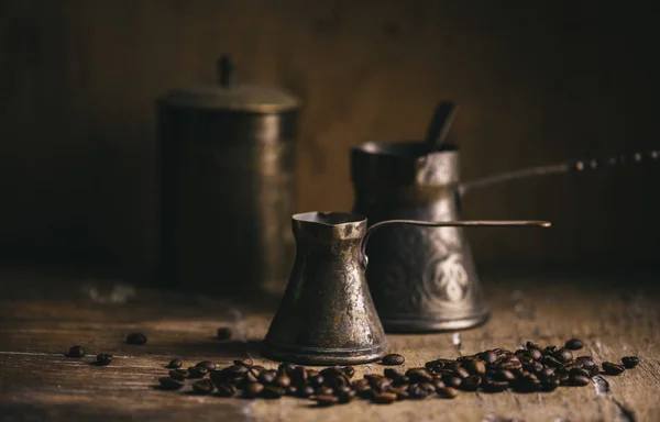 Panela de café velha e grão de café na mesa de madeira rústica. Vintage o — Fotografia de Stock