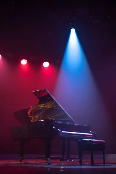 Sahne ışıkları altında piyano. Konserden önce.