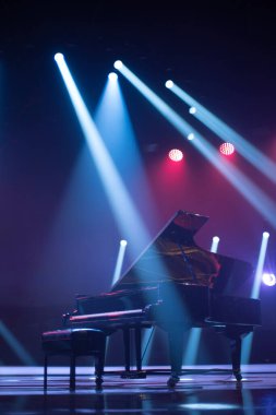 Sahne ışıkları altında piyano. Konserden önce.