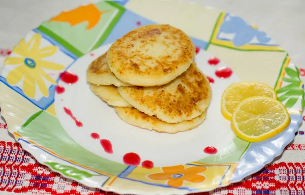 Блинчики с сыром на тарелке с лимоном — стоковое фото