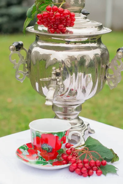 Samovar russo na mesa. Um pires e um copo. Viburno vermelho — Fotografia de Stock