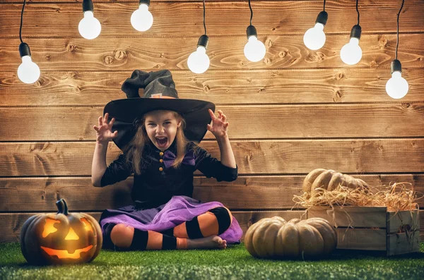 Little witch with a pumpkin. — Stock Photo, Image