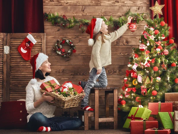 Moeder en dochter versieren de kerstboom. — Stockfoto