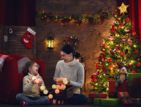 Mom and daughter decorate the Christmas tree.