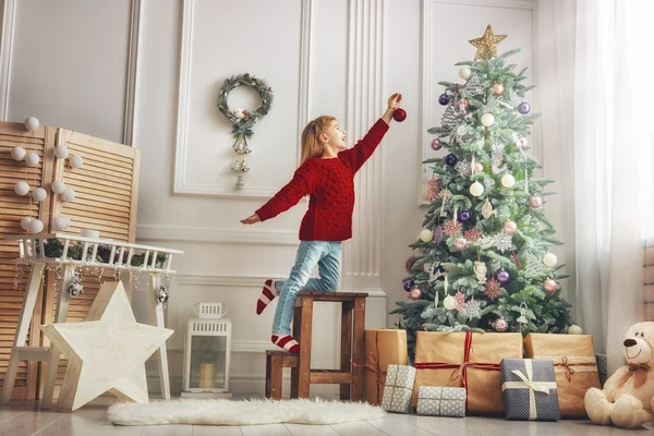 Chica está decorando el árbol de Navidad —  Fotos de Stock