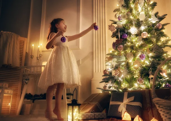 Meisje is de kerstboom versieren — Stockfoto