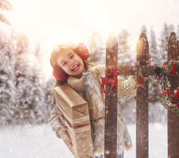 Flicka med julklapp på en vinterpromenad — Stockfoto