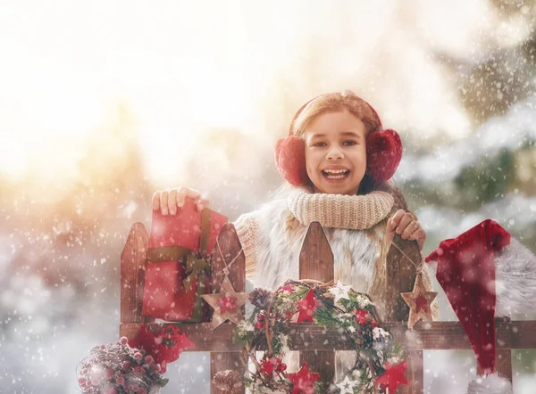 Flicka med julklapp på en vinterpromenad — Stockfoto