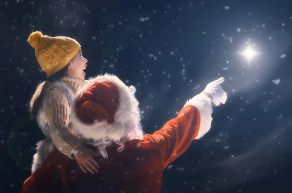Dziewczyna i Santa Claus patrząc na Boże Narodzenie gwiazda — Zdjęcie stockowe