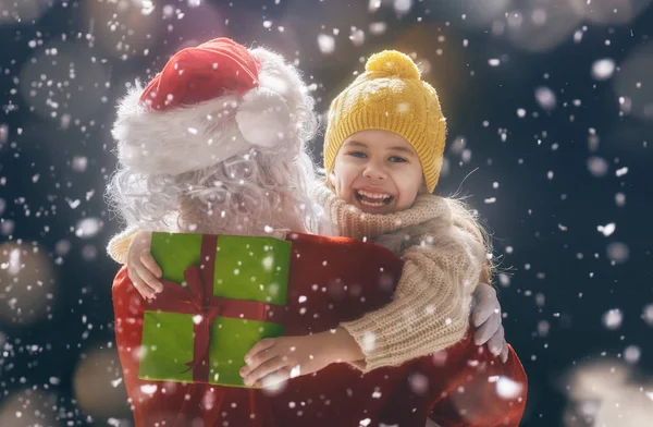 Ragazza abbracciare Babbo Natale — Foto Stock