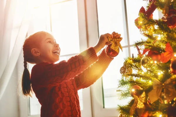Chica está decorando el árbol de Navidad — Foto de Stock