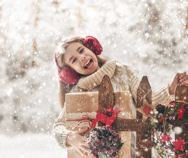 Meisje met de gift van Kerstmis op een winter wandeling — Stockfoto