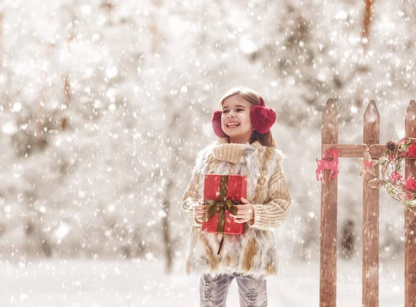 Menina com presente de Natal em uma caminhada de inverno — Fotografia de Stock