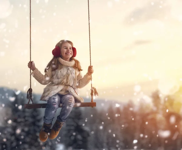 Mädchen auf Schaukel im Sonnenuntergang Winter — Stockfoto