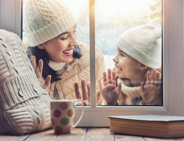 Kind en moeder op zoek in windows, permanent buitenshuis — Stockfoto