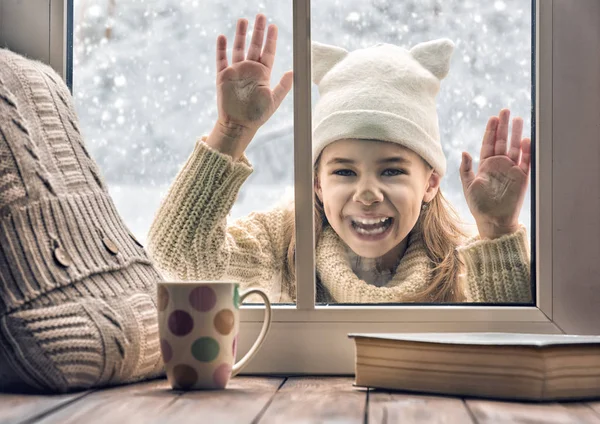 Girl looking in window — Stock Photo, Image