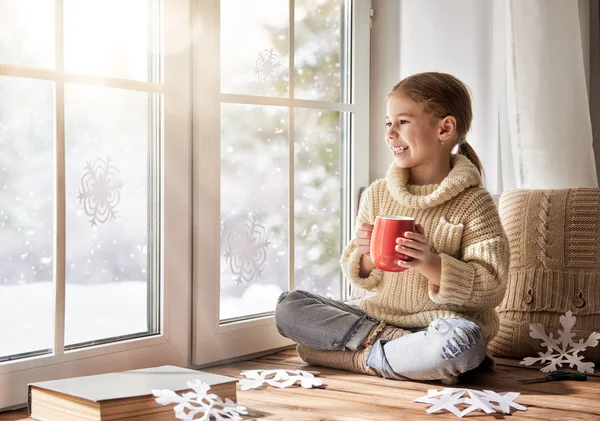 Criança faz flocos de neve de papel — Fotografia de Stock