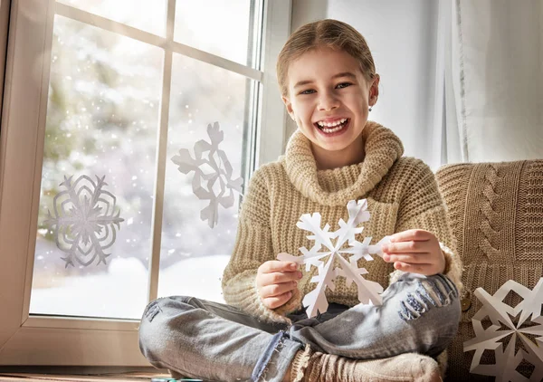 Ребенок делает бумажные снежинки — стоковое фото