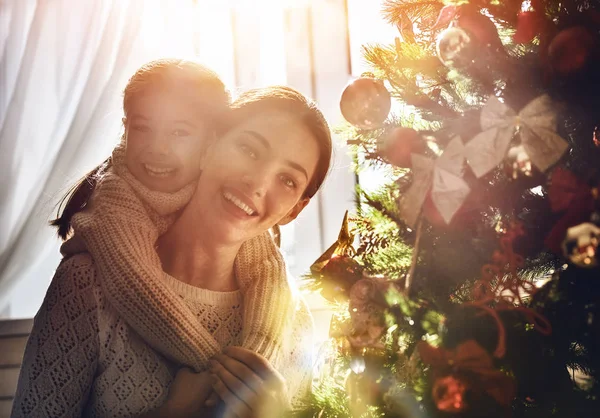 Mom and daughter decorate the Christmas tree