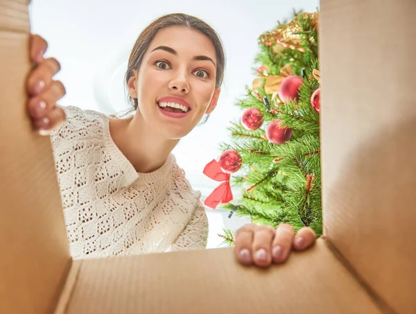Женщина, открывающая подарок на Рождество — стоковое фото