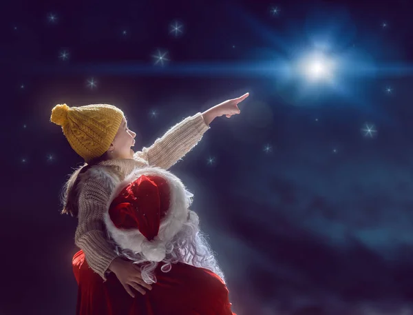 Menina e Papai Noel olhando para estrela de Natal — Fotografia de Stock