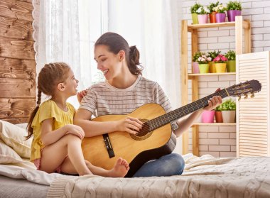 kadın kız çocuk için gitar çalmak