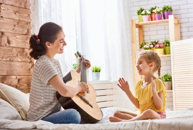 kadın kız çocuk için gitar çalmak