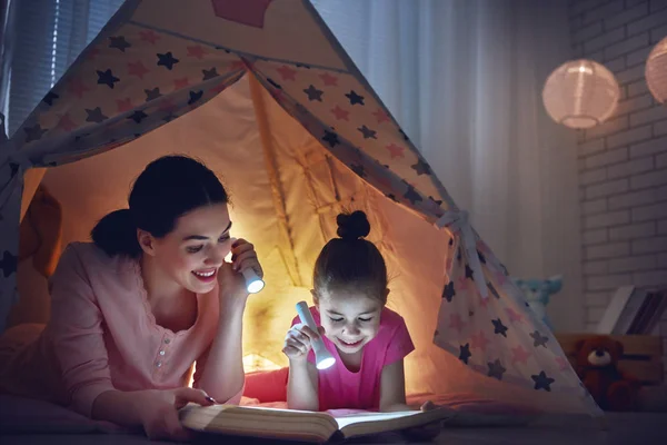 Mom and child daughter are reading a book — Stock Photo, Image