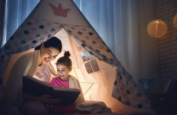 Mamá y su hija están leyendo un libro —  Fotos de Stock