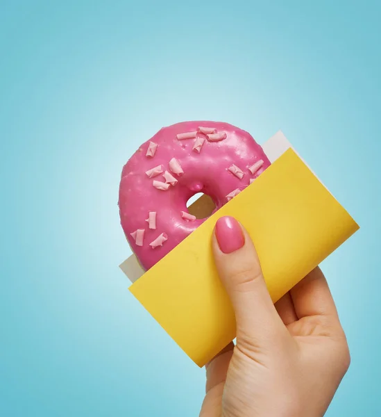 Donut with sprinkles in hand. — Stock Photo, Image