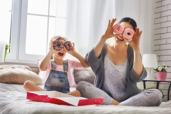 Moeder en haar dochter donuts eten — Stockfoto
