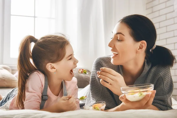 Matka a dcera jíst salát — Stock fotografie