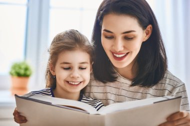 Anne ve kızı kitap okuyorlar.