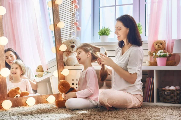 Mãe está penteando o cabelo de sua filha — Fotografia de Stock