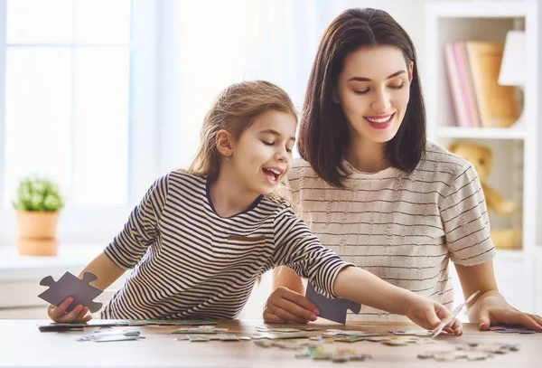 Mother and daughter do puzzles