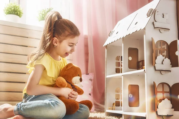 Girl plays with doll house — Stock Photo, Image