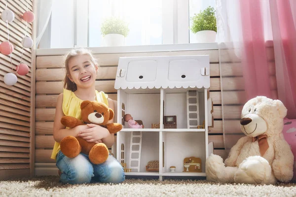 Girl plays with doll house — Stock Photo, Image