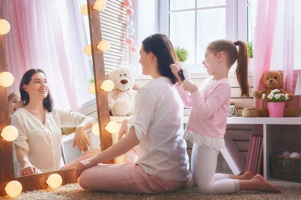 Menina está penteando o cabelo de sua mãe — Fotografia de Stock