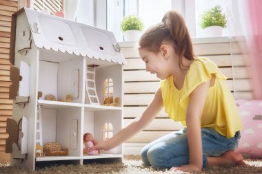 girl plays with doll house clipart