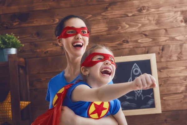 Mädchen und Mutter im Superheldenkostüm — Stockfoto