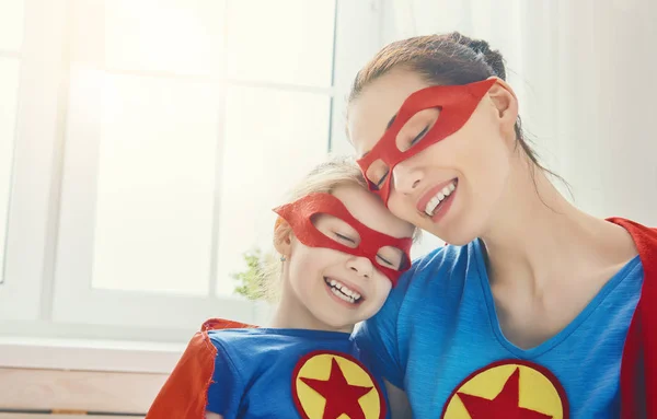 Meisje en moeder in een superheld kostuum — Stockfoto